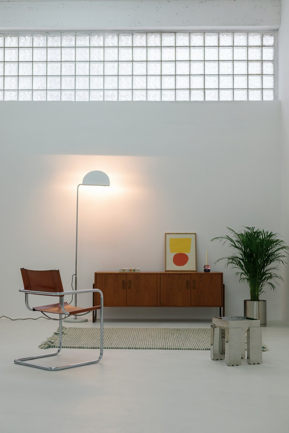 Stanza minimalista moderna con poltrona in pelle e pianta da interno.