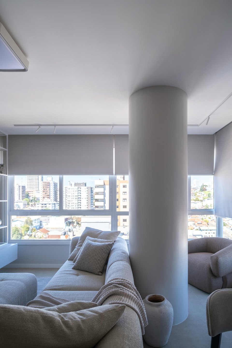 Arredamento moderno per soggiorno di fronte a una grande finestra con vista sullo skyline della città.