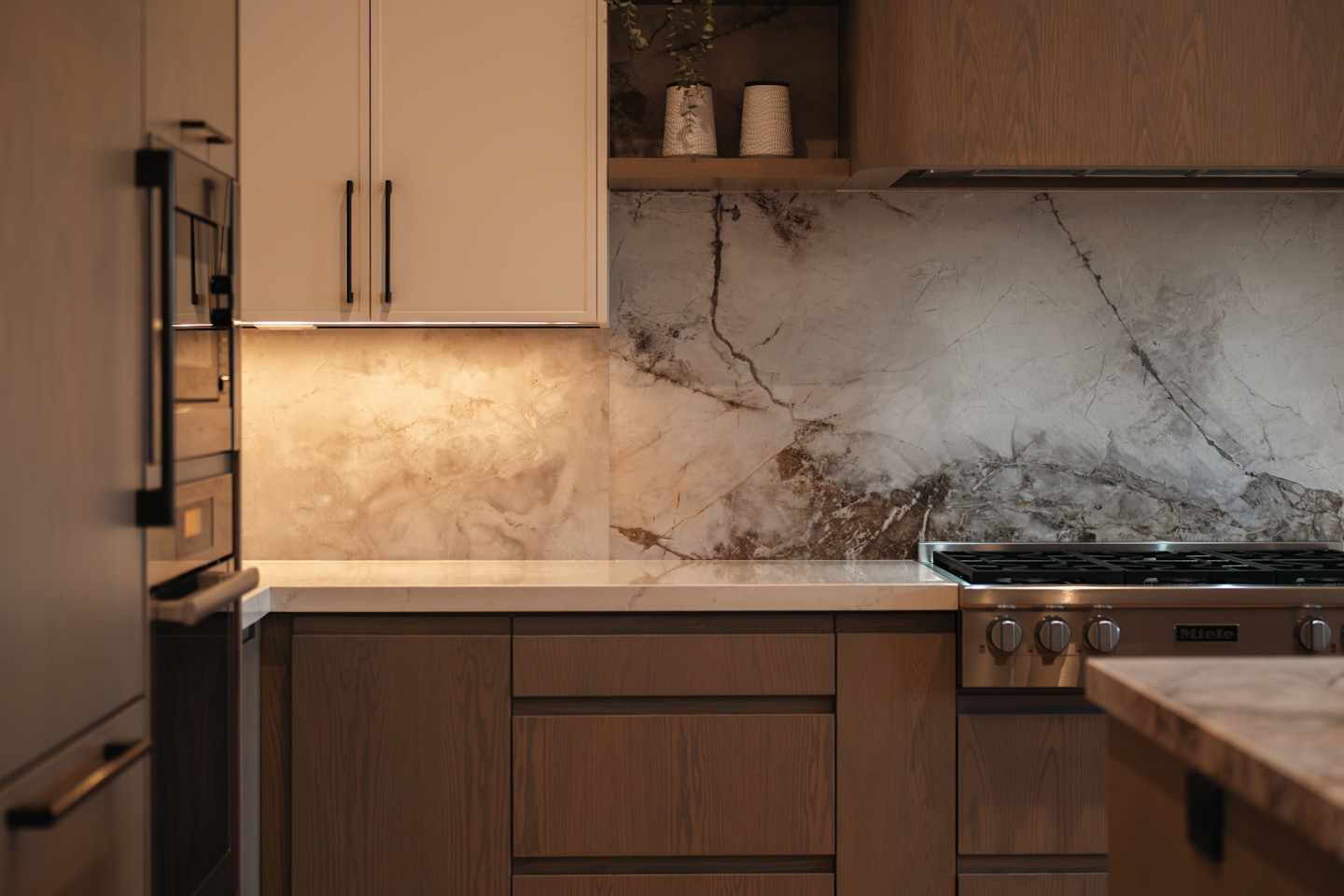 Cucina moderna con mobili in legno e piano di lavoro in marmo.