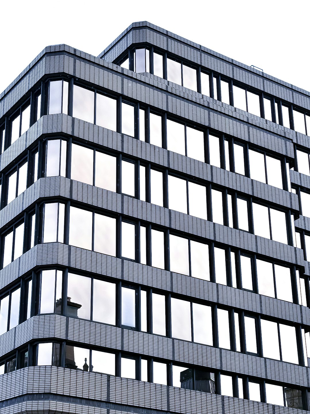 Moderno edificio per uffici a più piani con angoli in vetro curvo.